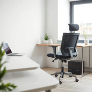 Ergonomik bel desteğine sahip konforlu çalışma koltuğu, modern ofiste sade bir masa ve gün ışığıyla