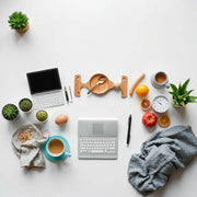 Doğal ışık alan modern bir ofiste ergonomik masa, düzenli çalışma alanı ve toplantı köşesi
