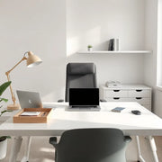 Doğal ışıklı modern bir ofiste düzenli masa, ergonomik sandalye ve laptop bulunan profesyonel çalışma alanı